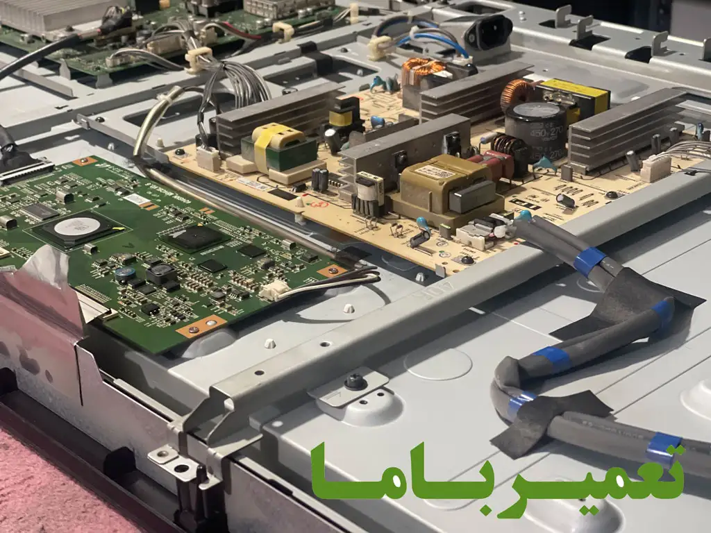 فنیکار در حال بررسی اتصالات و سیمکشی بین برد پاور، مینبرد و پنل تلویزیون پلاسما پاناسونیک