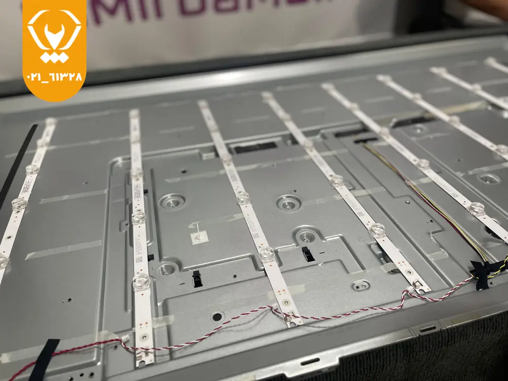 تکنسین در حال تست بکلایت داخلی تلویزیون با ابزار؛ تشخیص علت کمنور شدن
