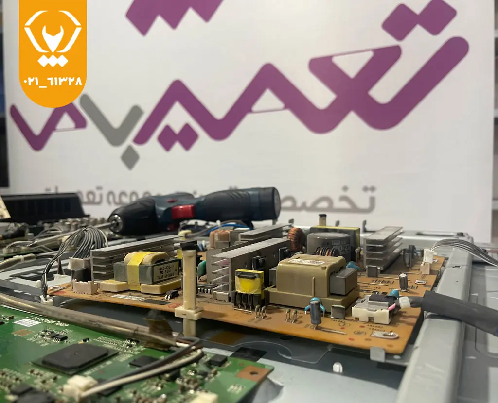تکنسین در حال بررسی و تست برد پاور تلویزیون الجی برای رفع داغ شدن غیرعادی